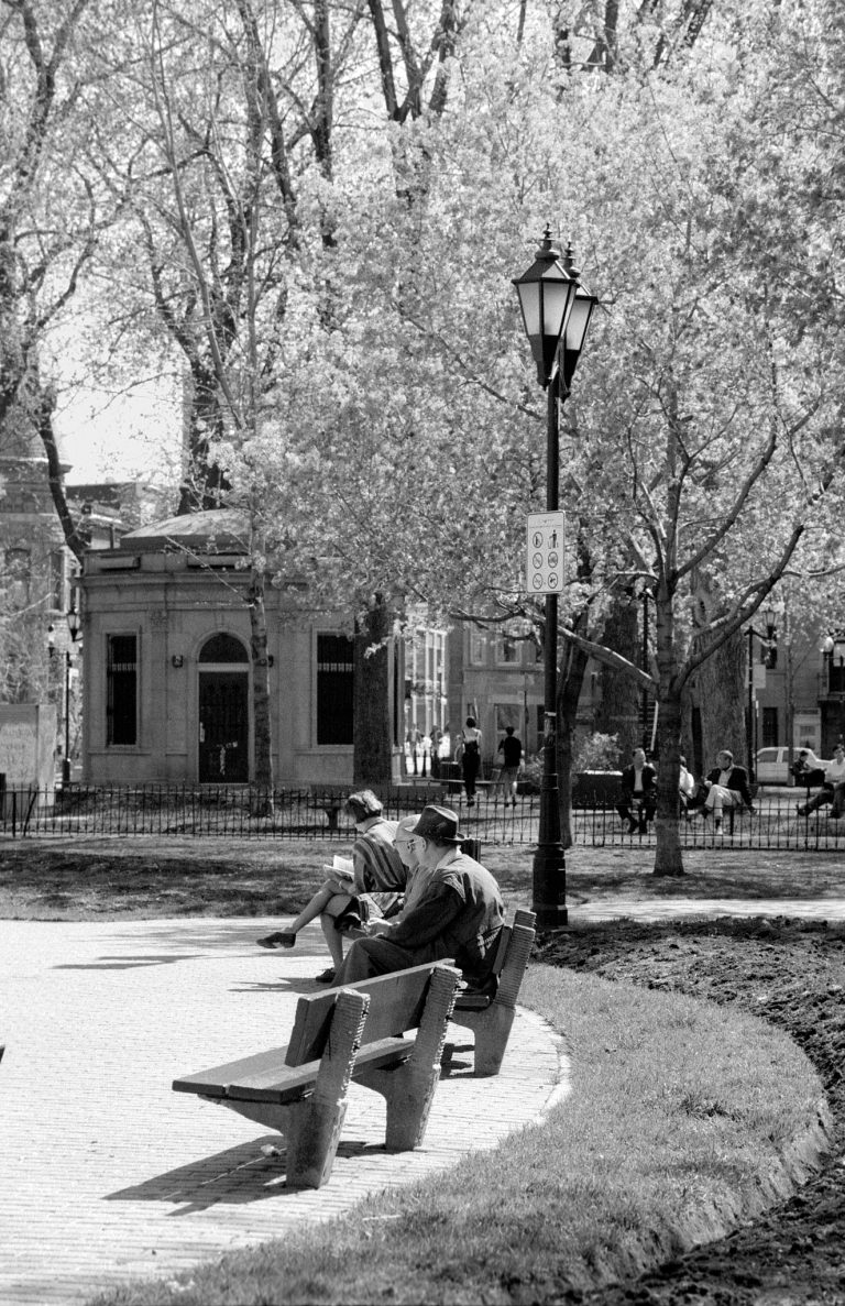 Mensen zitten op een bank in park in Montreal. Zwart wit foto